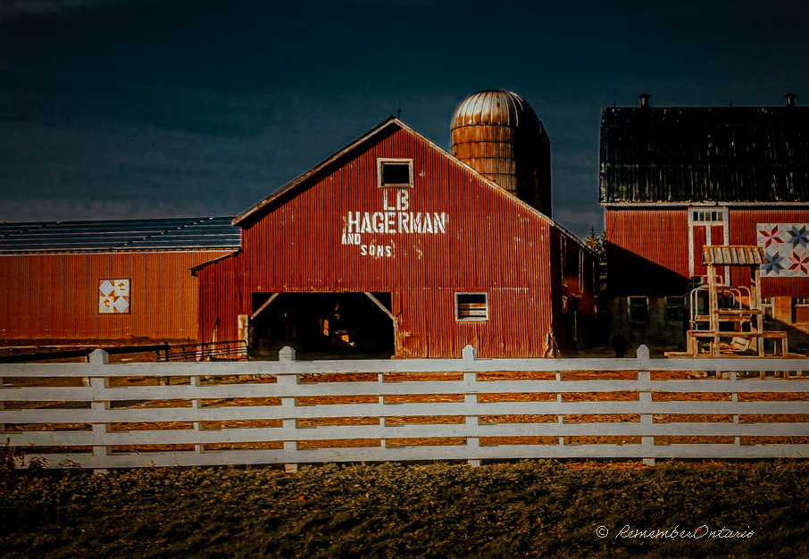 a red barn with a white fence in front of it