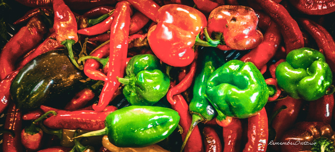 a large pile of red, green and yellow peppers