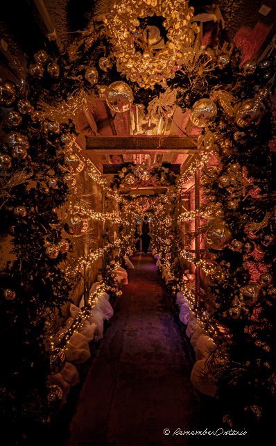 The tunnel under Casa Loma is decorated with golden light, baubles, and ornaments.