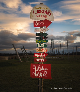 Red, white, and green signpost pointed to several locations in the Christmas Village.